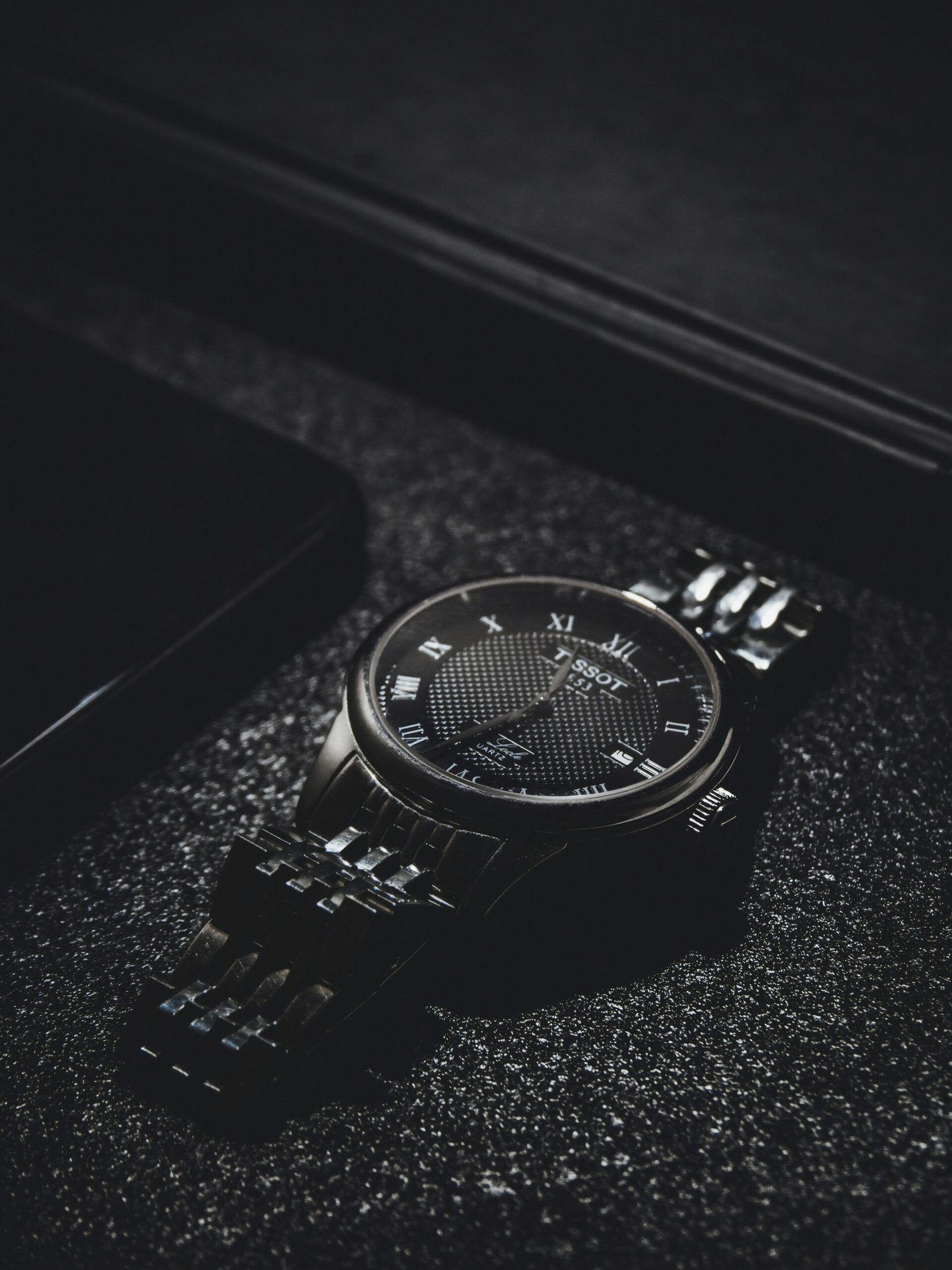 a watch sitting on top of a black table